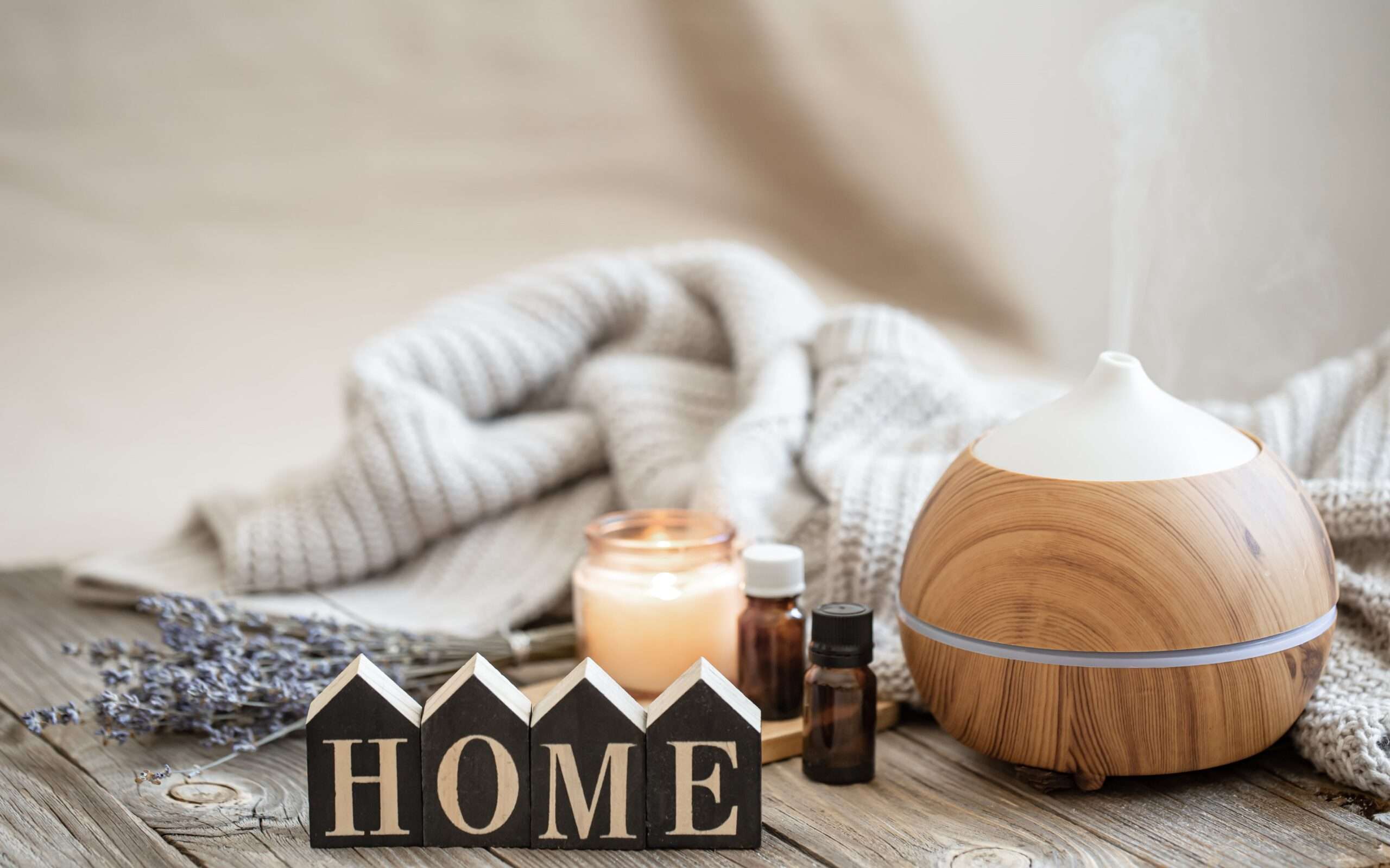aroma composition with modern aroma oil diffuser wooden surface with knitted element oils candle min scaled